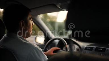 一个人开车，他的爱人把他的手放在他的肩膀上。